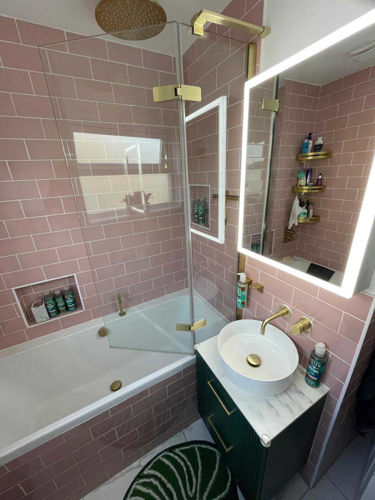 Pink-tiled bathroom with brass fittings cleaned to a high standard